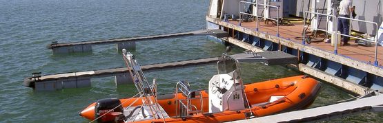 Orange båt som ligger till vid båtplats hos Depåservice
